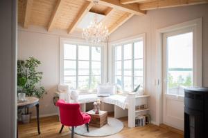 a living room with a chandelier and red chairs at Kleine SeenSucht in Neukieritzsch