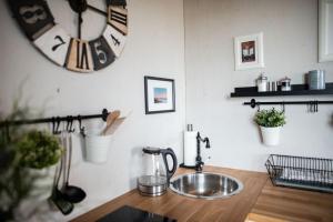 a kitchen with a sink and a clock on the wall at Kleine SeenSucht in Neukieritzsch