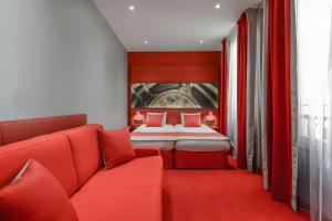a red bedroom with a bed and a couch at Hôtel Regina Opéra Grands Boulevards in Paris