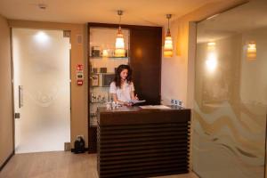 a woman standing at a counter in a restaurant at Hotel Crepei in Pozza di Fassa +75 photos
