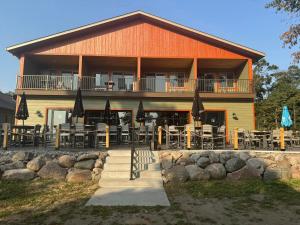 a building with tables and umbrellas in front of it at Cass Lake Lodge in Cass Lake