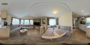 a living room with a table and a kitchen at De´ Borns Mobielhome in Rheinsberg