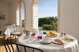 a table with breakfast food on it in a room at Isola Charm B&B - Pool & Nature Stay in Syracuse