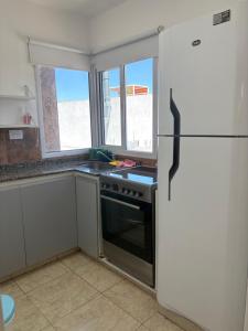 a kitchen with a stove and a refrigerator at Amelia 2-1 in Villa Carlos Paz