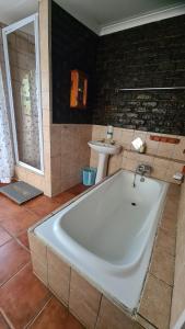 a large bath tub in a bathroom with a sink at Eagles guest house Piet Retief in Piet Retief