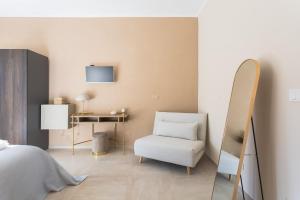 a bedroom with a bed and a chair and a mirror at Casa Scioli in Caraglio