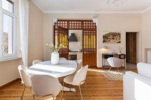 a white dining room with a white table and chairs at Casa Scioli in Caraglio