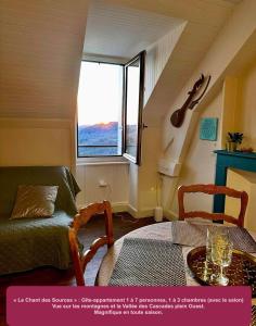 a room with a bed and a table and a window at Le Chant des Sources, Gîtes et Chambres d'hôtes avec Vue, à Gimel-les-Cascades in Gimel