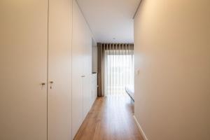 a room with white walls and a bed and a window at Terro Collection - Alcaide in Braga