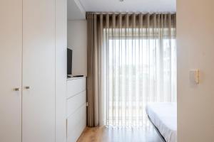 a bedroom with a bed and a large window at Terro Collection - Alcaide in Braga