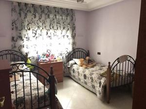 a bedroom with two beds and a window at ma chambre in Casablanca