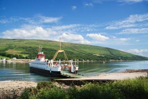 a boat is docked at a dock in the water at The Harbour House - Deluxe Town Centre Property in Rothesay