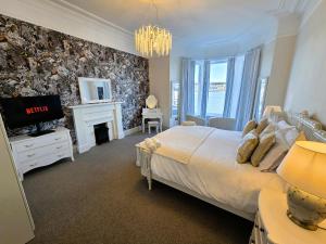a bedroom with a bed with a fireplace and a television at The Harbour House - Deluxe Town Centre Property in Rothesay