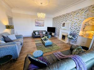 a living room with two couches and a fireplace at The Harbour House - Deluxe Town Centre Property in Rothesay