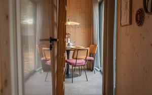 a dining room with a table and chairs in a room at Tinyhouse luxe met privé hottub in Meerssen
