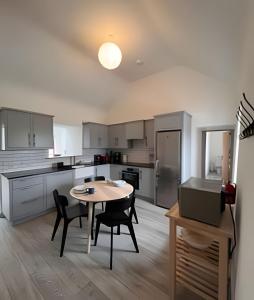 a kitchen with a table and chairs in a room at Bunowen, Louisburgh, Walk to the Beach! in Louisburgh