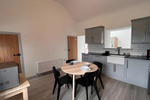 a kitchen with a table and chairs in a room at Bunowen, Louisburgh, Walk to the Beach! in Louisburgh +17 photos