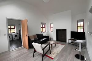 a living room with a couch and a table at Bunowen, Louisburgh, Walk to the Beach! in Louisburgh