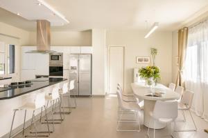 a white kitchen with a white table and chairs at Villa Felicity in Svoronata