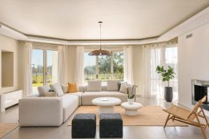 a living room with a white couch and a fireplace at Villa Felicity in Svoronata