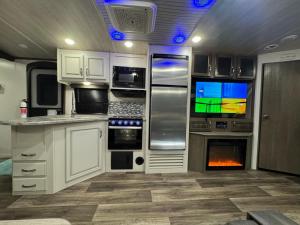 an rv kitchen with a tv and a fireplace at Sunset Combate in Cabo Rojo