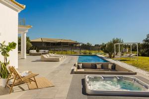 a patio with a hot tub in the middle of a yard at Villa Felicity in Svoronata