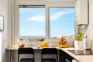a kitchen with a counter with chairs and a window at Gran Sol 3BR - Sea View - AC & Wifi - 10 min to Beach in Rincón de la Victoria