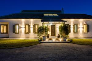 a white house with lights on the front of it at Villa Felicity in Svoronata