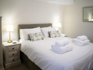 a bedroom with a white bed with towels on it at Whitehouse Farm in Hartington +14 photos