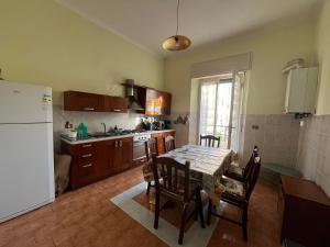 a kitchen with a table and chairs and a refrigerator at Villa Mehari in Pisa