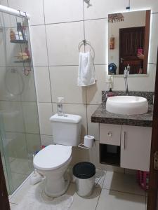 a bathroom with a toilet and a sink at Quarto em residência familiar in Navegantes