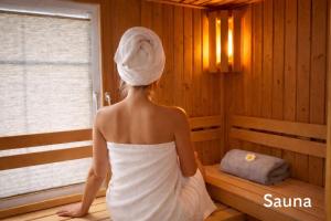 a woman in a sauna with a towel on her head at Villa Mara - für 12 Gäste, Sauna, 1 Wirlwanne, 2 Duschen, Kamin, 5 SZ, 3 WC, Highspeed Internet, abgezeuntes Grundstück in Glowe