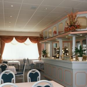 a restaurant with tables and chairs and a counter at Pension Waldfrieden in Wolkenstein