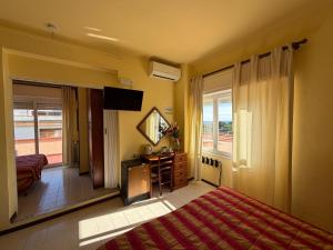 a bedroom with a bed and a television and a window at Hotel Nettuno in Diano Marina