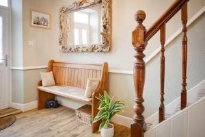 a hallway with a bench and a mirror at Northern Hideaways, Darling Cottage in Seahouses