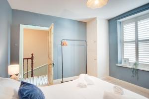 a bedroom with a bed and a blue wall at Northern Hideaways, Darling Cottage in Seahouses