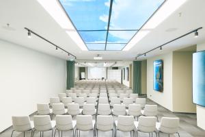an empty lecture hall with white chairs and a skylight at BRISTOL Hotel Opatija in Opatija