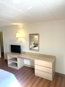 a room with a desk with a television and a bed at Big Springs Inn in Big Springs