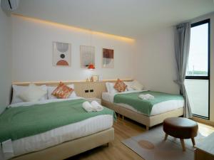 a hotel room with two beds and a window at Hello Teepak A34 in Ban Bo Prakhon
