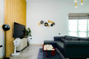 a living room with a blue couch and a tv at Hello Teepak A34 in Ban Bo Prakhon
