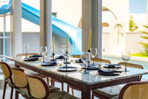 a long table with chairs and wine glasses on it at Hello Teepak A34 in Ban Bo Prakhon
