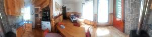 a living room with a kitchen with a table at Casita Ancestral in Puerto Aisén