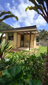 a small house with a porch with a table at Vai Hea Lodge in Taputapuapea