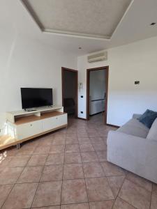 a living room with a couch and a flat screen tv at Rolly Home - Verona Apartment in Verona