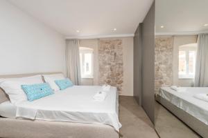 a bedroom with two beds and two windows at Riva Lavanda Hvar, Old Town in Hvar
