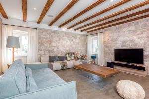 a living room with a couch and a tv at Riva Lavanda Hvar, Old Town in Hvar