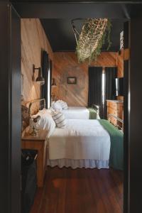 a bedroom with two beds with white sheets at The Gilded Lady - The Cypress Suite in Pensacola
