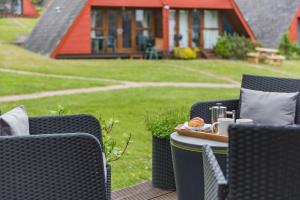 a patio with two chairs and a table with a tray of food at Chalet 53 in Deal