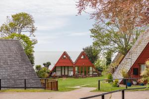 a row of cottages with the ocean in the background at Chalet 53 in Deal
