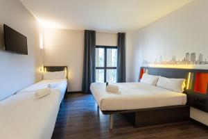 a hotel room with two beds and a tv at easyHotel Barcelona Fira in Hospitalet de Llobregat +63 photos